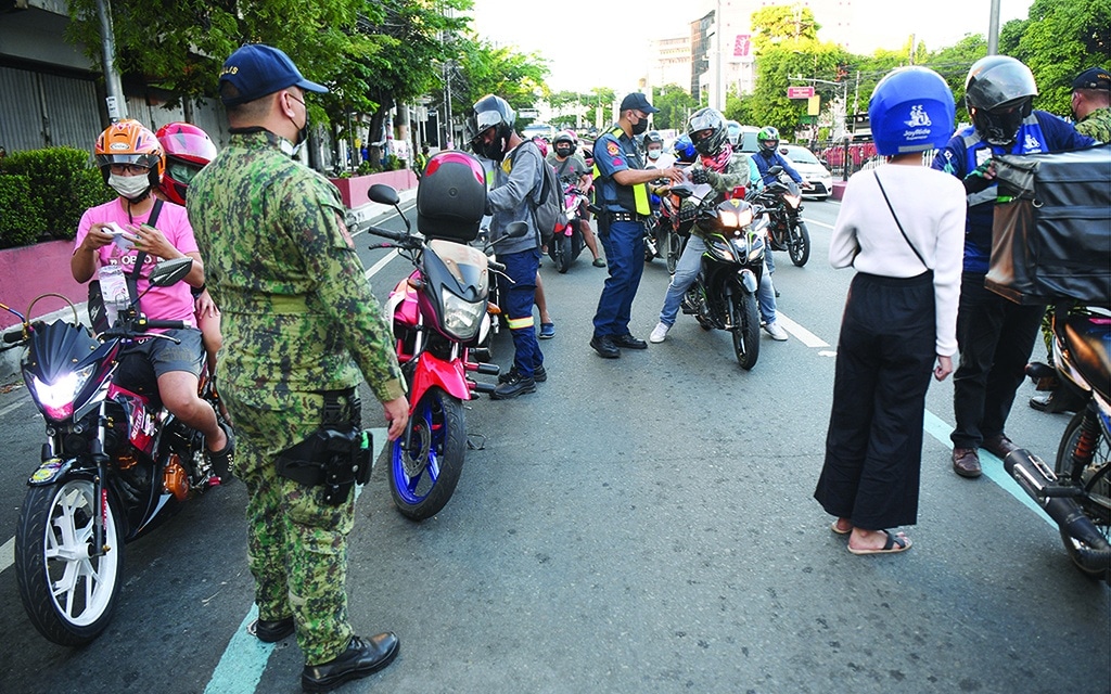 MANILA: Police officers check documents of motorists at a check point along a road in Manila City, on May 8, 2022, a day before the May 9 presidential election. - AFP