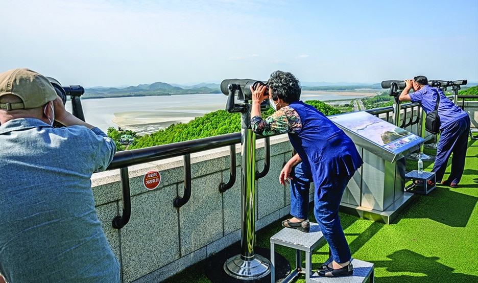 SEOUL: Visitors use binoculars to look towards the North Korean side of the Demilitarized Zone (DMZ) from the Odusan Unification Tower in Paju on May 12, 2022. – AFP