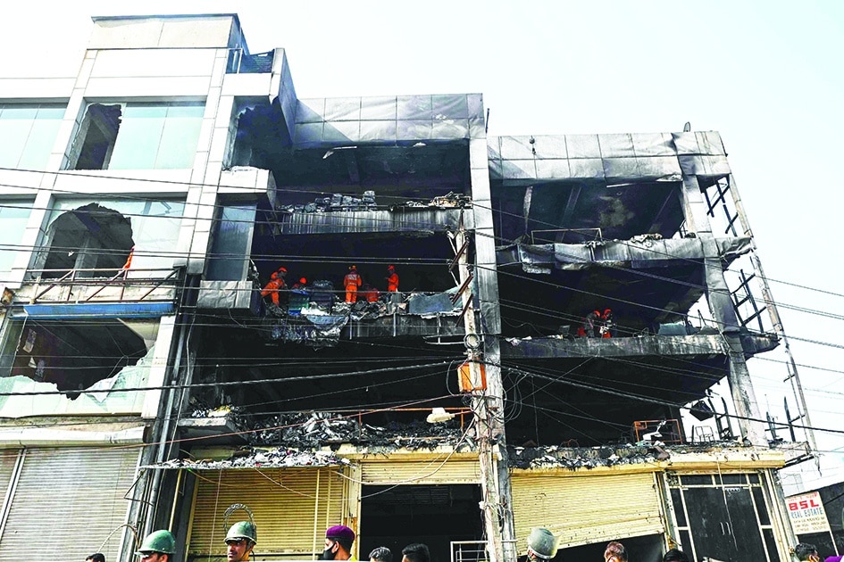 NEW DELHI: National Disaster Response Force members and firefighters inspect a commercial building a day after a fire broke out in New Delhi on May 14, 2022. - AFP