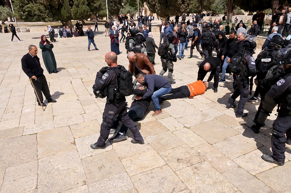 JERUSALEM: Two people lie on the ground during clashes between Zionist police and Palestinians on May 5, 2022 following a visit by a group of Jewish people at the al-Aqsa mosque compound which is the site of Islam's third-holiest place . — AFP