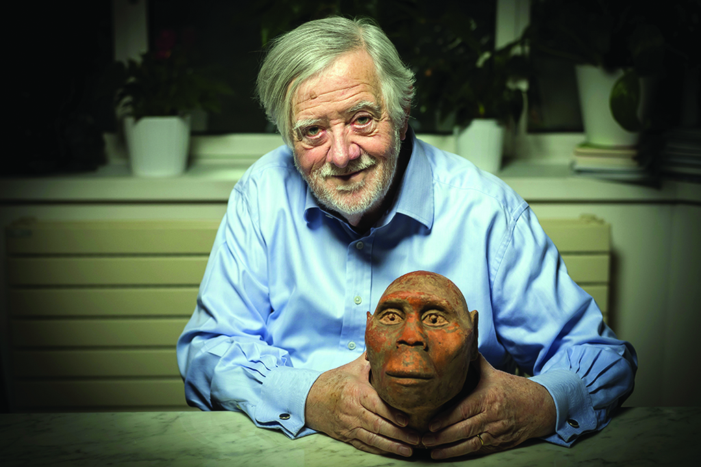 This file photograph shows French paleontologist Yves Coppens posing at his home in Paris, while holding a head model of Lucy, a female australopithecus. – AFP