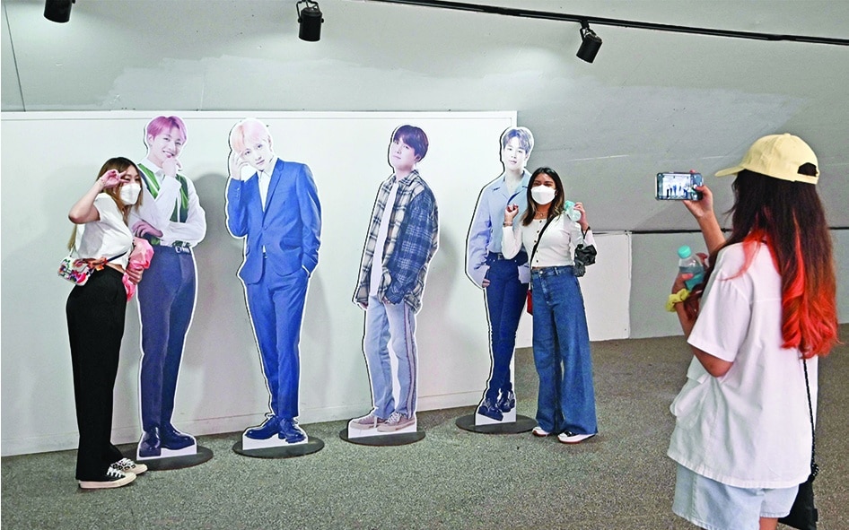 Visitors pose with card board cut outs of K-pop group BTS members for their souvenir photos at a tourist information center in Seoul. — AFP photos