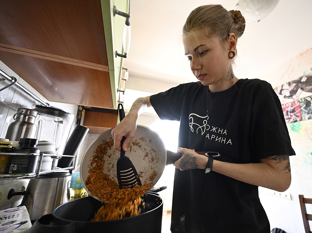 In a photograph taken in Kyiv on June 7, 2022, volunteer Masha prepares a vegan meal made of bulgur wheat for civilians in Kyiv, amid Russian invasion of Ukraine. - AFP