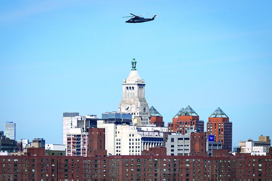 A helicopter flies above the city skyline of New York. 