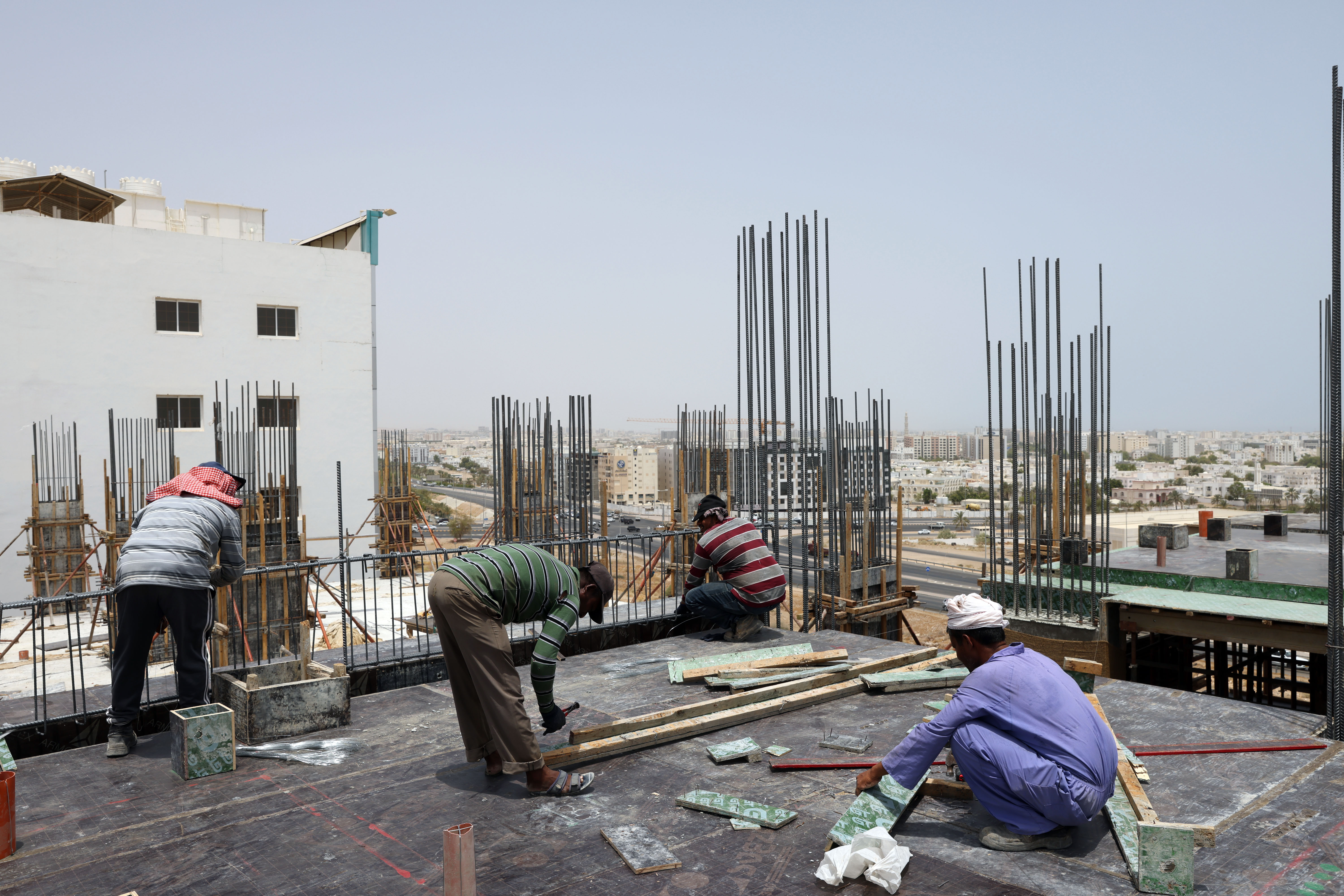 Foreign laborers work at a construction site in the Omani capital Muscat, amid scorching heat, on June 21, 2022. - AFP 