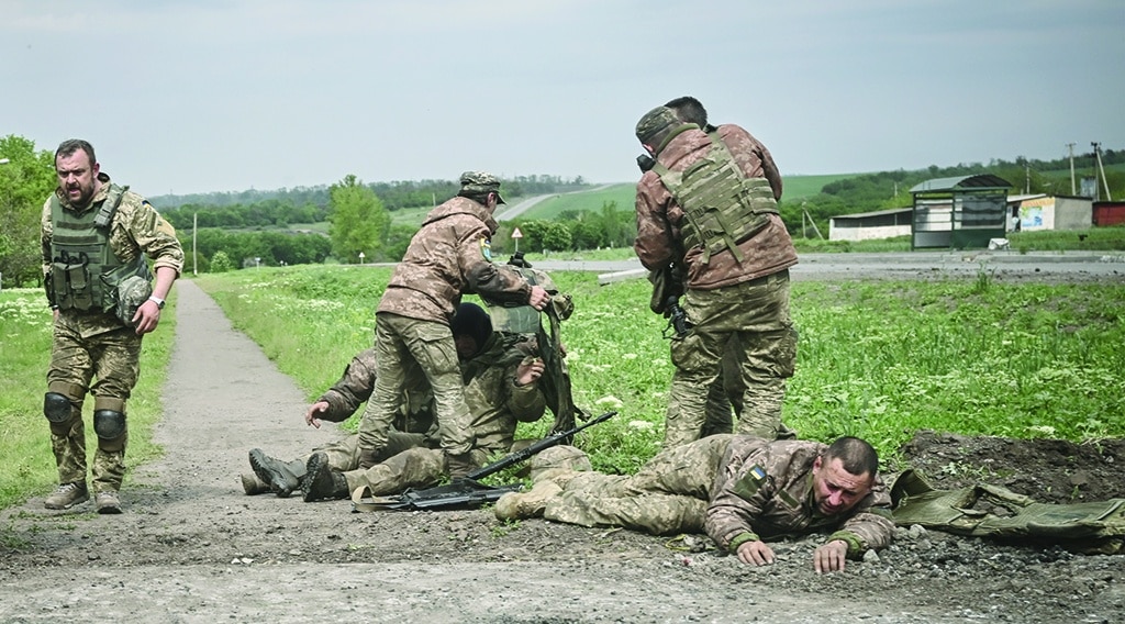 NOVYI DONBAS, Ukraine: Ukrainian servicemen assist their comrades not far from the frontline in the eastern Ukrainian region of Donbas. - AFP