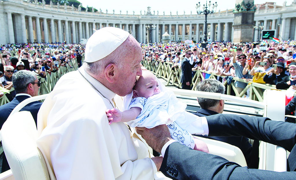 VATICAN CITY: File photo shows Pope Francis kissing a baby from the popemobile car within a canonization mass at St Peter's Square in The Vatican. - AFP