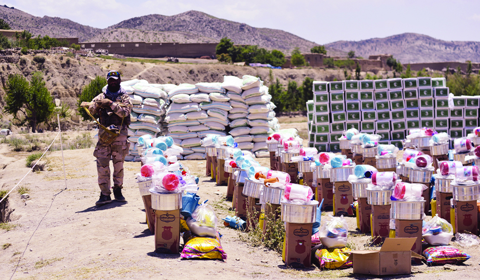 GAYAN: In this photograph taken on June 25, 2022, a Taleban fighter stands guard beside the aid supplies for the people affected by recent earthquake in Gayan district of Paktika province. - AFP