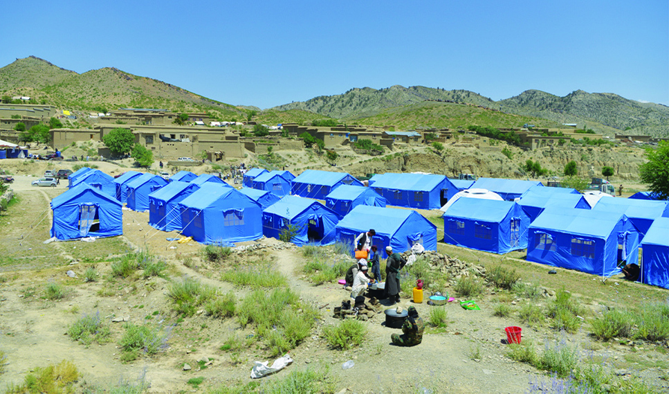 GAYAN: In this photograph taken on June 25, 2022, men cook outside temporary tents for the earthquake affected people in Gayan district of Paktika province. - AFP
