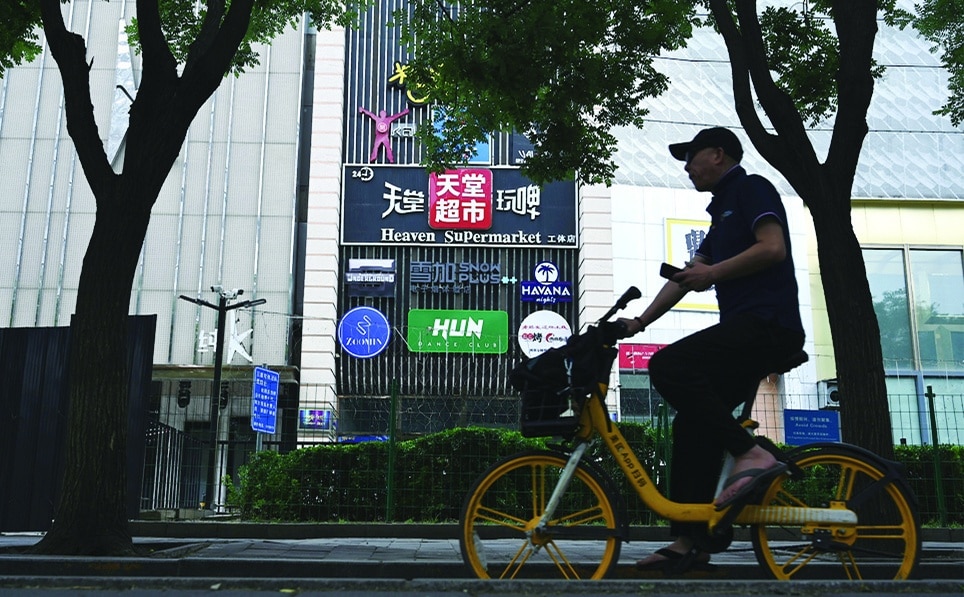 BEIJING: A man pedals a bicycle past the Heaven Supermarket bar where a COVID-19 coronavirus outbreak emerged in the Chaoyang district of Beijing. - AFP