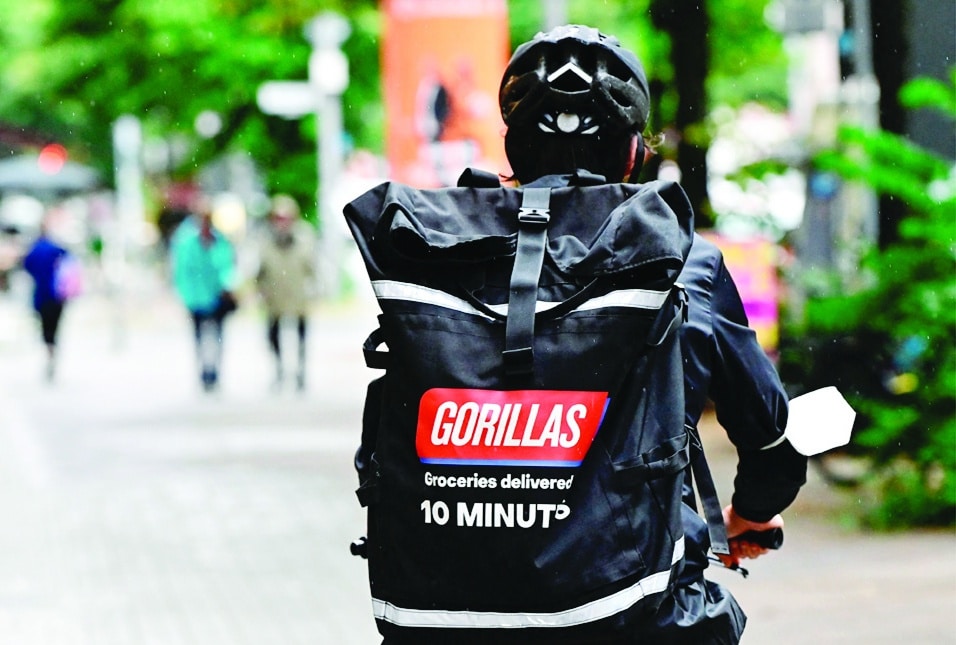 BERLIN: A bicycle courier of grocery delivery company 'Gorillas' wears a backpack with the logo of the startup on his way to deliver purchases in Berlin. - AFP