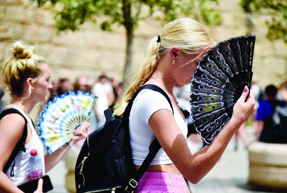 SEVILLE: Two women use fans to fight the scorching heat during a heatwave in Seville. -  AFP