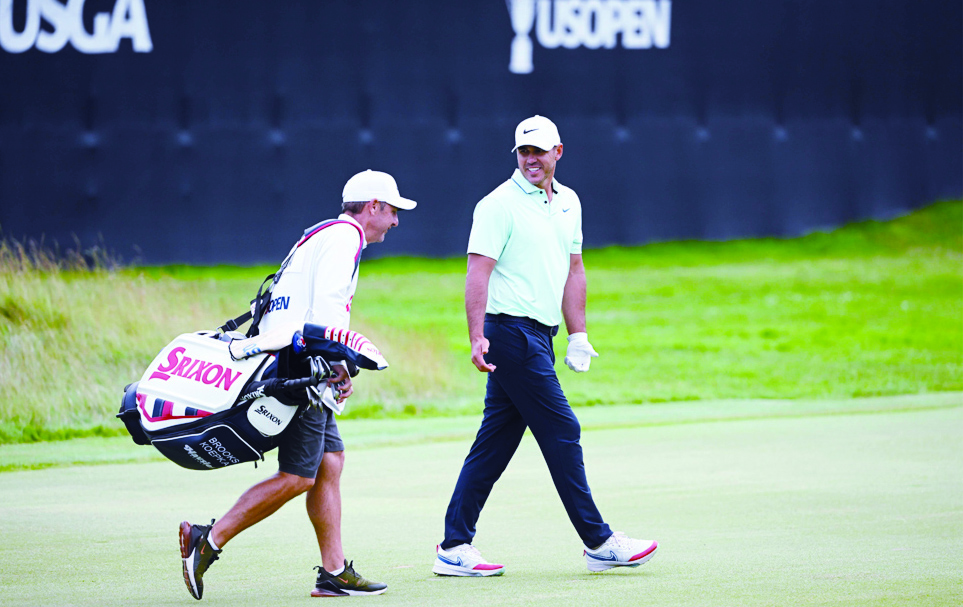 BROOKLINE: Brooks Koepka of the United States and caddie Ricky Elliott walk the 18th green during the third round of the 122nd US Open Championship at The Country Club in Brookline.- AFP