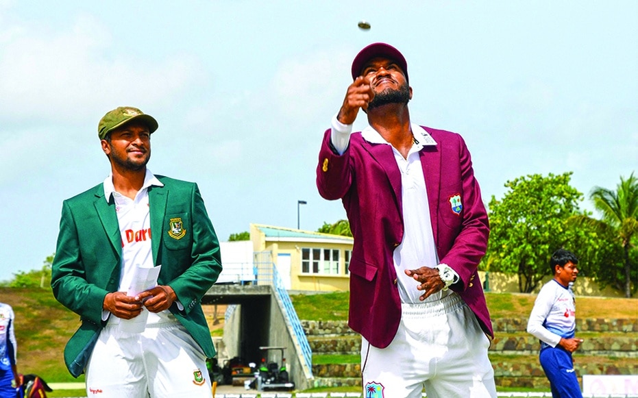 NORTH SOUND: Kraigg Brathwaite of West Indies tosses the coin as Shakib Al Hasan of Bangladesh watches during the 1st day of the 1st Test between Bangladesh and West Indies at Vivian Richards Cricket Stadium in North Sound, Antigua and Barbuda, on June 16, 2022. - AFP
