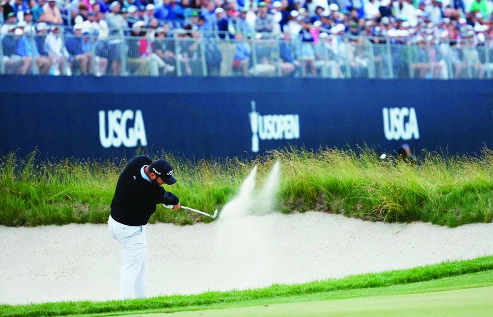 BROOKLINE: Jon Rahm of Spain plays a second shot from a fairway bunker on the 18th hole during the third round of the 122nd US Open Championship at The Country Club on June 18, 2022.- AFP