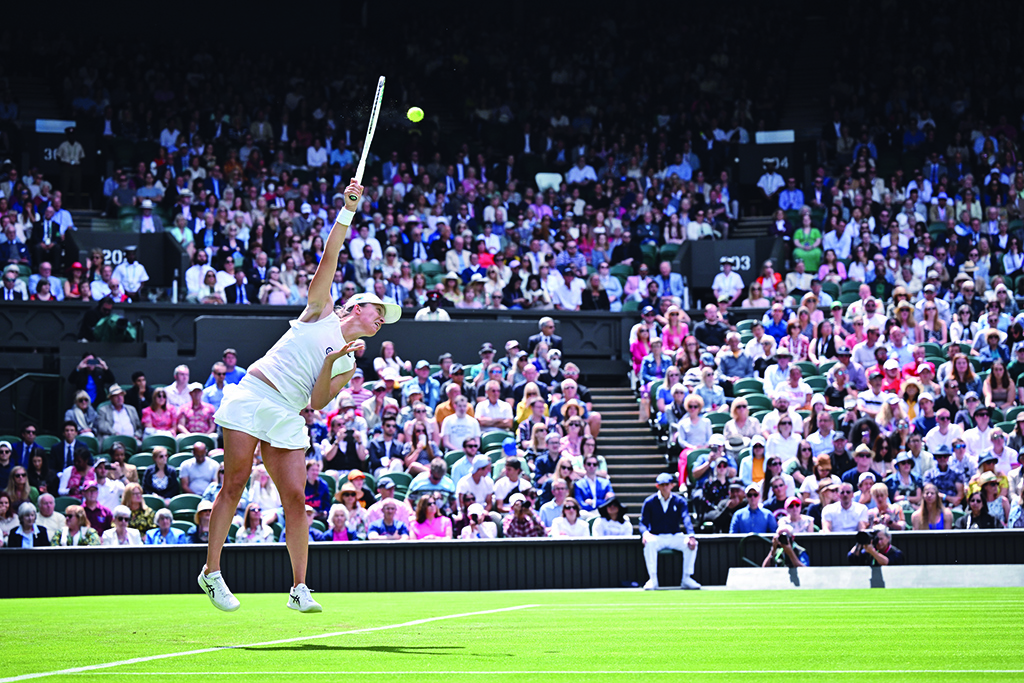 WIMBLEDON: Poland's Iga Swiatek serves the ball to Croatia's Jana Fett during their women's singles tennis match on the second day of the 2022 Wimbledon Championships at The All England Tennis Club in Wimbledon on June 28, 2022.- AFP
