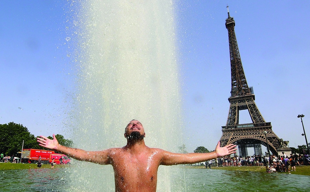 PARIS: A man cools off in the Trocadero Fountains across from the Eiffel Tower on June 18, 2022 amid record high temperatures sweeping across France and western Europe. - AFP