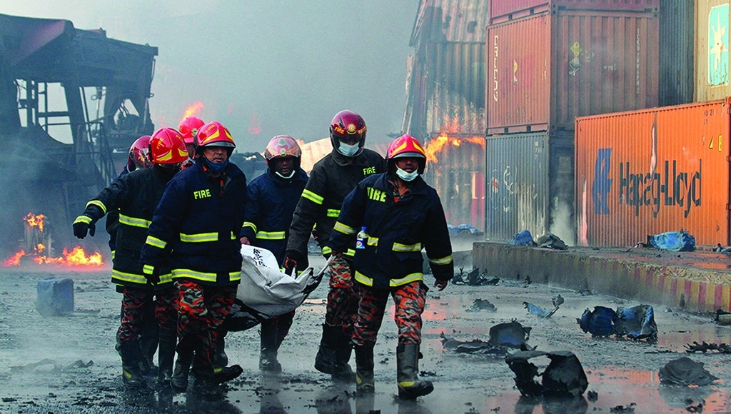 SITAKUNDA, Bangladesh: Firefighters carry the body of a victim from the site after a fire broke out at a container storage facility about 40 km from the key port of Chittagong on June 5, 2022. - AFP