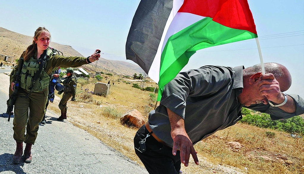TUBAS: A Zionist soldier pepper sprays a Palestinian demonstration on June 6, 2022 during a gathering to denounce Zionist settlement expansion in the Jordan Valley. - AFP