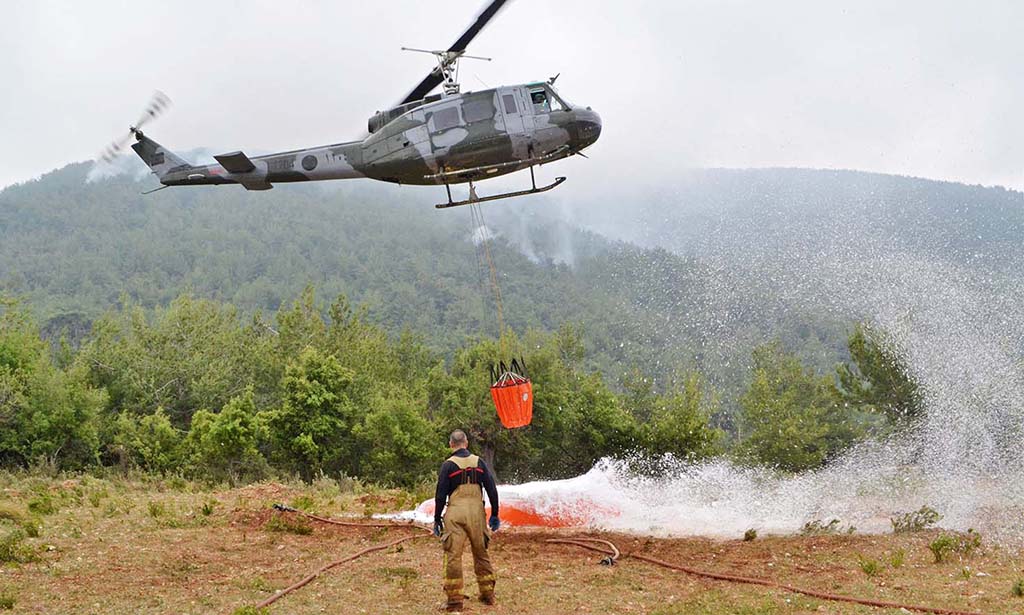 DINNIYEH, Lebanon: A firefighting helicopter refills its water bucket to battle the Batramaz forest fire on June 8, 2022. - AFP