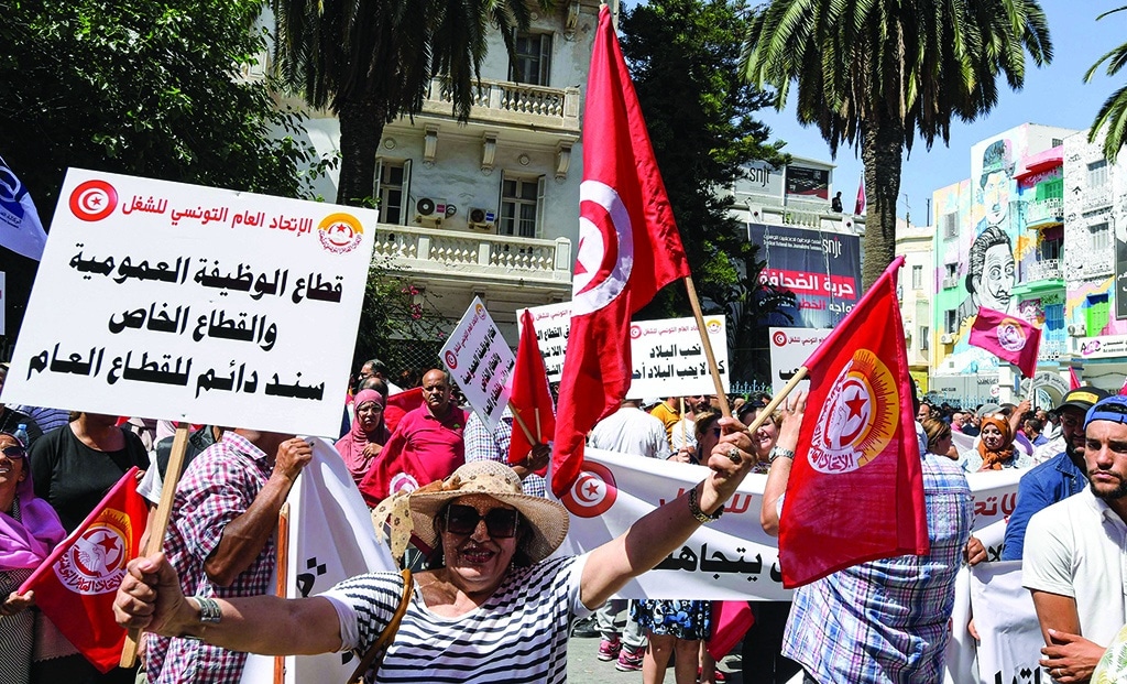 TUNIS: Supporters of the Tunisian General Labor Union (UGTT) gather with national flags during a rally outside its headquarters on June 16, 2022 amidst a general strike. - AFP
