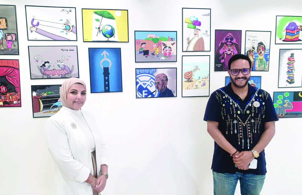 AMMAN: Caricaturists Mona Al-Tamimi and Mohammad Al-Qahtani in front of the Kuwaiti pavilion at the caricature exhibition. - KUNA photos