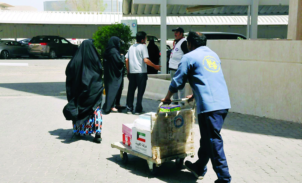 KUWAIT: KRCS workers distribute aid to widows. - KUNA
