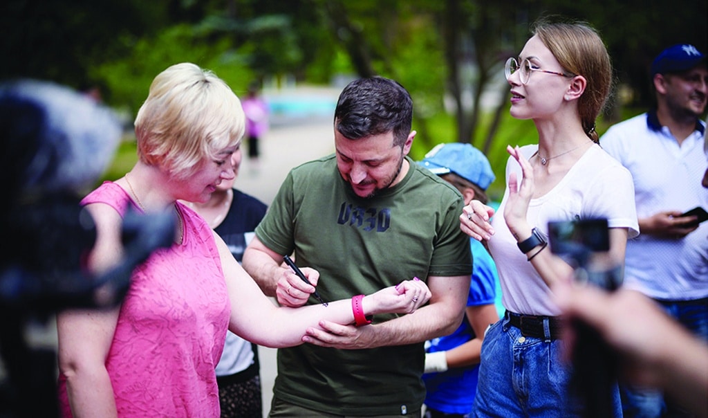 ZAPORIZHZHIA, Ukraine: Handout picture released by the Ukrainian presidential press service, shows Ukrainian President Volodymyr Zelensky signing a woman's arm as he visits a sanatorium where Ukrainians who had been forced to leave their homes after the Russian invasion were housed during a working trip to the Zaporizhzhia region. - AFP