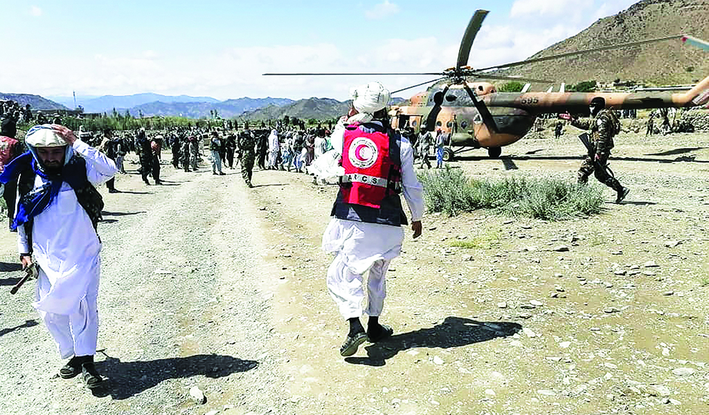 GAYAN, Afghanistan: Soldiers and Afghan Red Crescent Society officials stand near a helicopter at an earthquake hit area in Afghanistan's Gayan district, Paktika province. A powerful earthquake struck a remote border region of Afghanistan overnight killing over 1,000 people and injuring hundreds more, officials said. – AFP