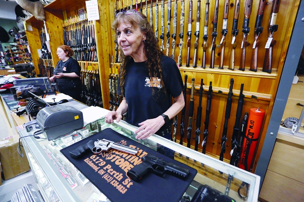 OTTAWA, Canada: Lavigne, co-owner of That Hunting Store, speaks with customers in Ottawa, Canada. Canadians rushed to buy handguns this week, after Prime Minister Justin Trudeau announced a proposed freeze on sales in the wake of recent mass shootings in the US. - AFP