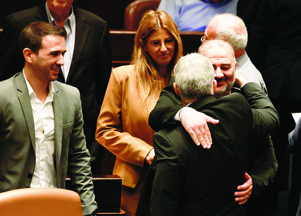 JERUSALEM: Head of Zionist entity's conservative Islamic Raam party Mansour Abbas embraces Zionist Minister of Foreign Affairs Yair Lapid, following the dissolution of the parliament, in Jerusalem on June 30. -AFP