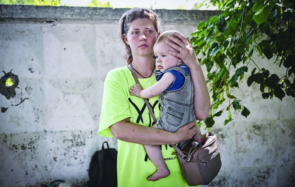 LYSYCHANSK, Ukraine: A woman holds her baby as she waits to board a bus and evacuates from the city of Lysychansk in the eastern Ukraine region of Donbas on June 9, 2022, as Russian forces have for weeks been concentrating their firepower on Severodonetsk and its sister city of Lysychansk across the river. - AFP
