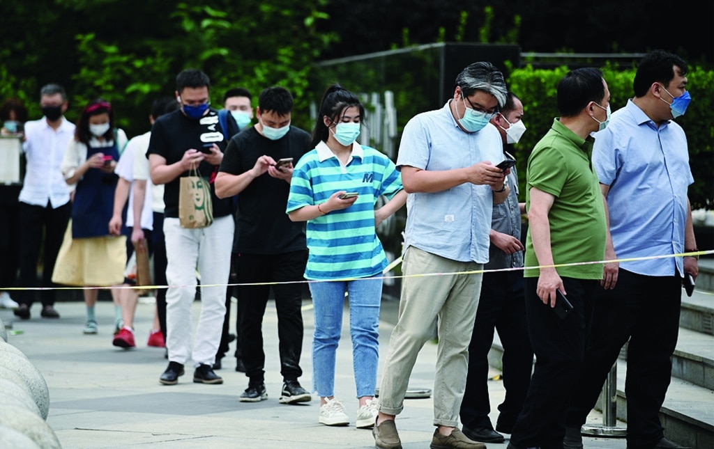 People queue for a swab test for Covid-19 coronavirus at a swab collection site in Beijing on June 14, 2022. (Photo by Noel Celis / AFP)
