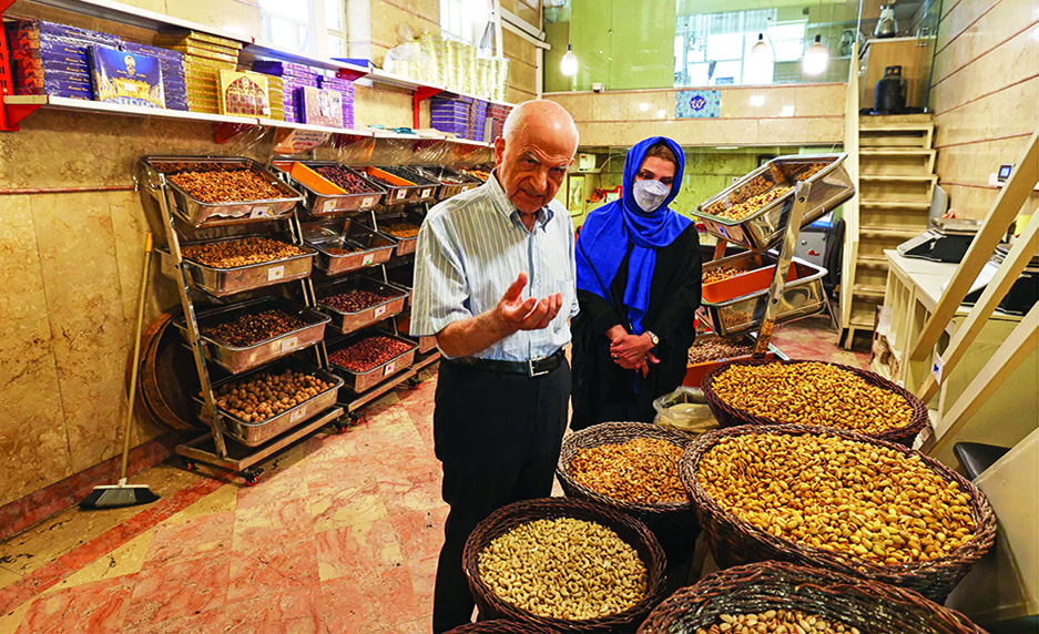 TEHRAN: Abbas Emami (left), 88, and his daughter Marjan display pistachios inside his shop in Tehran's famous Graz Bazaar. Tucked away in Tehran's famous bazaar, Iran's oldest pistachio wholesaler quietly prepares a small revolution-he will hand his business to his youngest daughter, in a trade dominated by men. - AFP photos