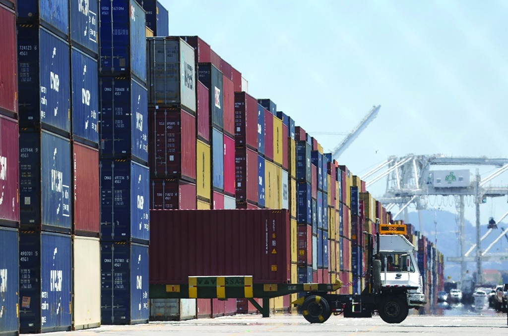 OAKLAND: A truck drives by stacks of containers at the Port of Oakland, California. -- AFP