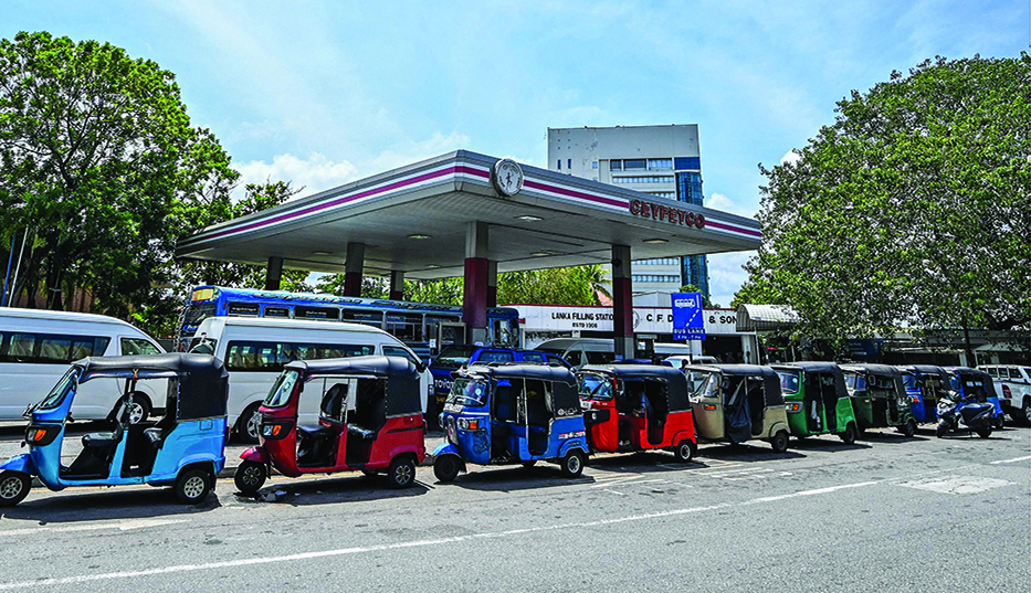 COLOMBO: Auto-rickshaws are parked in a queue along a street to tank up petrol from a Ceylon petroleum corporation fuel station in Colombo on June 20, 2022. - AFP
