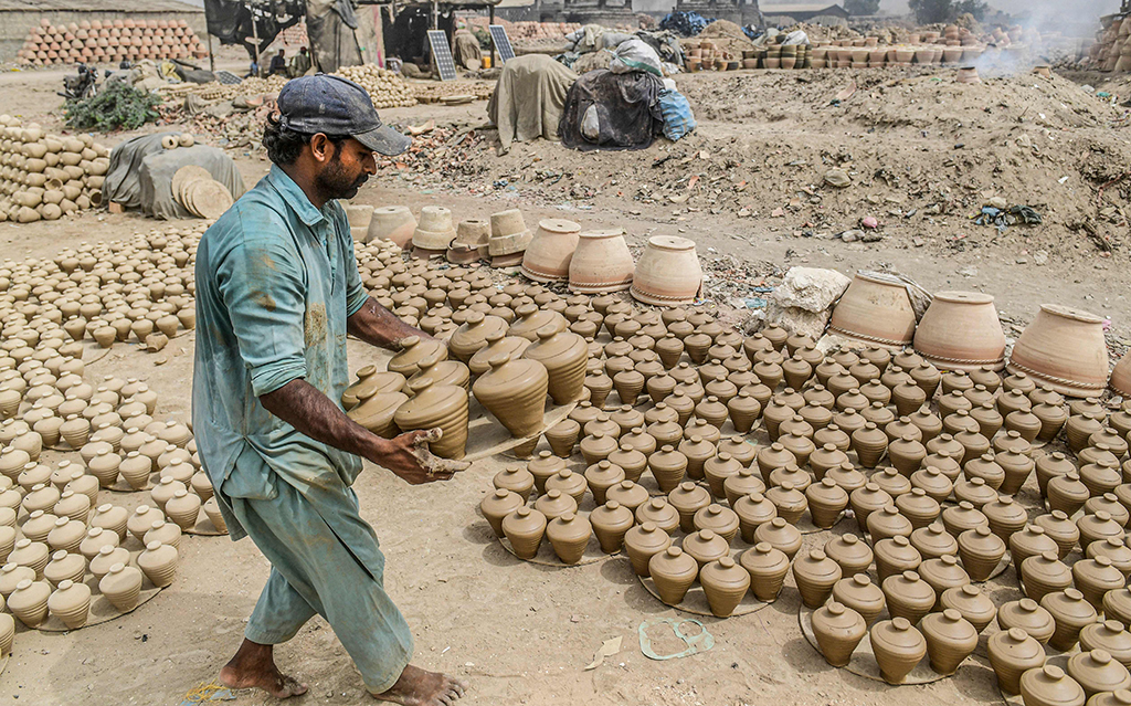 KARACHI: Laborers work at a clay pot workshop on the outskirts of Karachi.- AFP