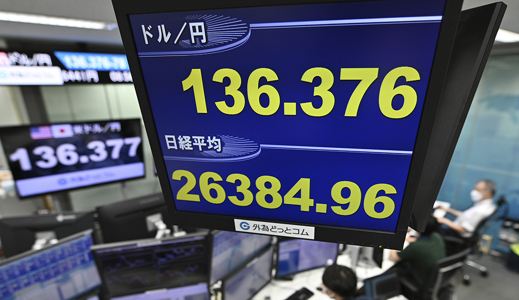 TOKYO: An electronic quotation board displays the yen's rate against the US dollar (top) and the share price of the Tokyo Stock Exchange (bottom) at a foreign exchange brokerage in Tokyo. -  AFP