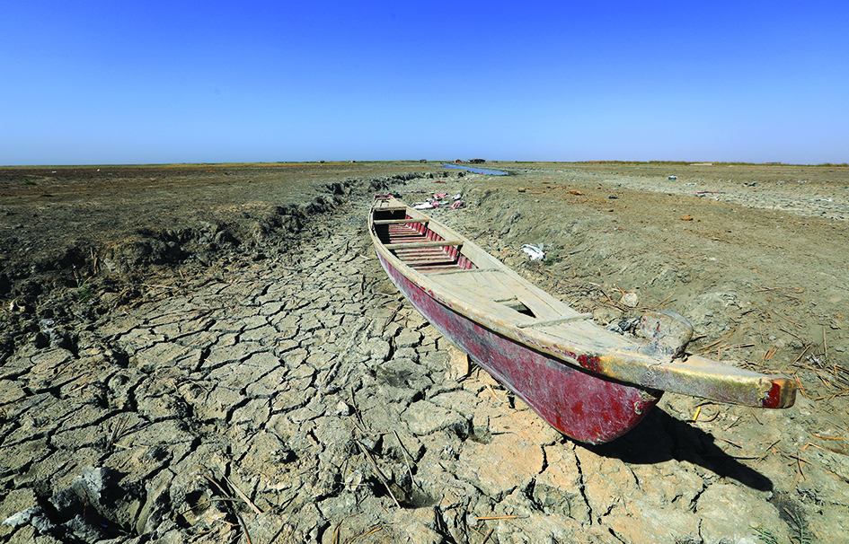 DHI QAR: A boat lies on the dried-up bed of a section of Iraq's receding southern marshes of Chibayish in Dhi Qar province, on June 28, 2022. Iraq's drought reflects a decline in the level of waterways due to the lack of rain and lower flows from upstream neighboring countries Iran and Turkey. - AFP