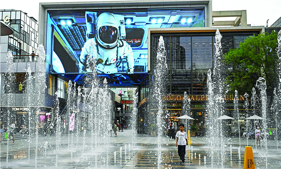 BEIJING: A child plays at an outdoor fountain at a shopping mall in Beijing on June 28, 2022. - AFP