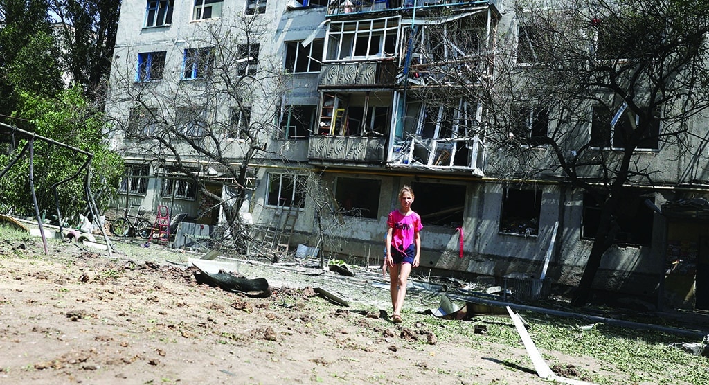 BAKHMUT, Ukraine: A local resident walks outside her building, partialy destroyed as a result of a night airstrike, in the town of Bakhmut, Donetsk Oblast, on June 13, 2022, amid Russia's military invasion launched on Ukraine. - AFP