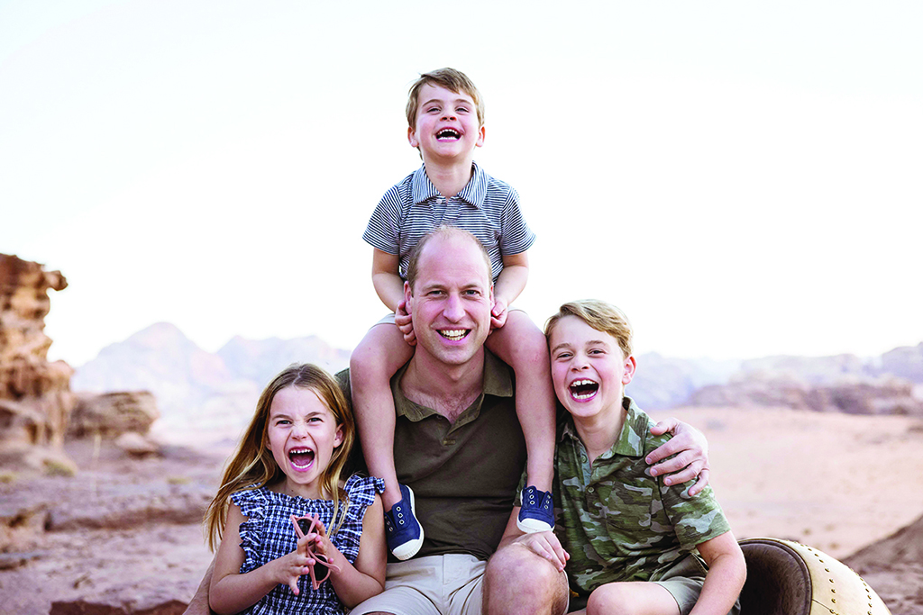 A handout picture released by Kensington Palace on June 18, 2022 shows Britain's Prince William posing for a photograph with his children, Prince Louis, Princess Charlotte and George, taken in Jordan in Autumn 2021 and released to mark Father's Day 2022. - AFP