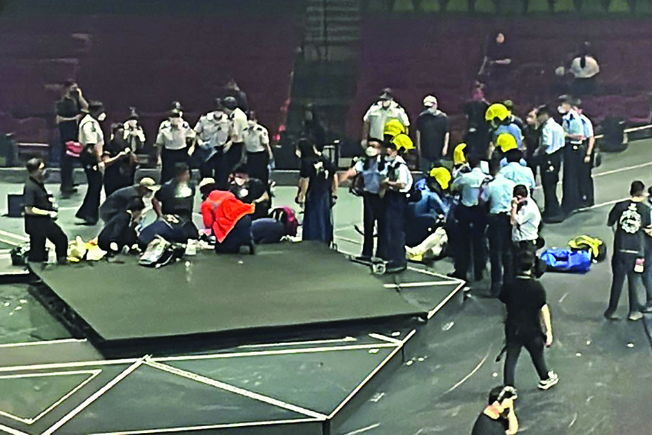 This handout photo courtesy of an anonymous shows paramedics (front left and right) treating two dancers on stage after an overhead video screen fell during a concert by boy band Mirror at the Hong Kong Coliseum in Hong Kong. - AFP photos