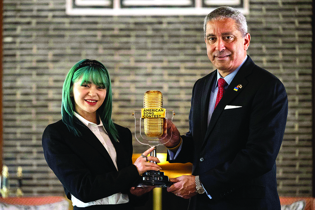 In this photo Korean-American K-pop star AleXa (left), holds her recently won American Song Contest trophy with Christopher Del Corso, the US charge d'affaires ad interim in Seoul, at the residence of the US ambassador in Seoul. - AFP photos