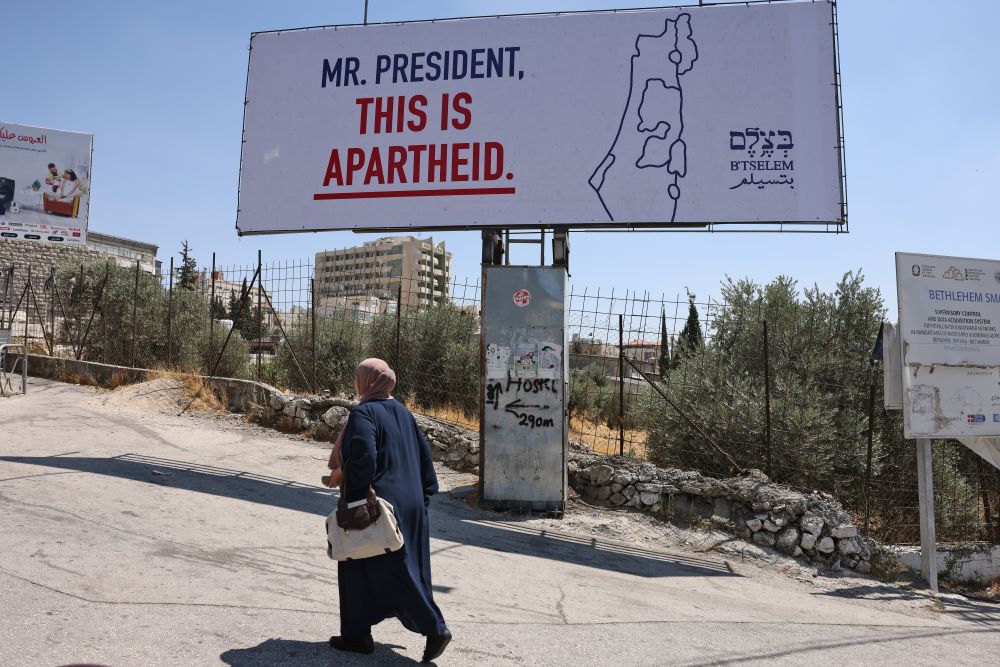 Bethlehem: A woman walks past a billboard, part of a campaign organized by Israeli rights group B'Tselem, in the West Bank city of Bethlehem on July 13, 2022, ahead of US President's arrival for an official visit. -- AFP 