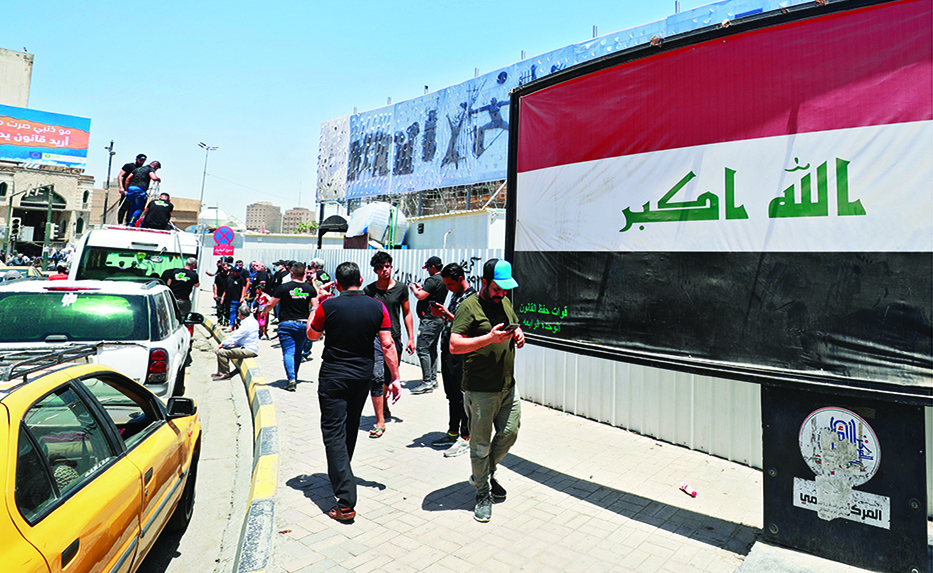 BAGHDAD: Iraqis walk along a street in central Baghdad's Tahrir Square on July 28, 2022, a day after supporters of Shiite cleric Muqtada al-Sadr stormed the country's parliament. - AFP