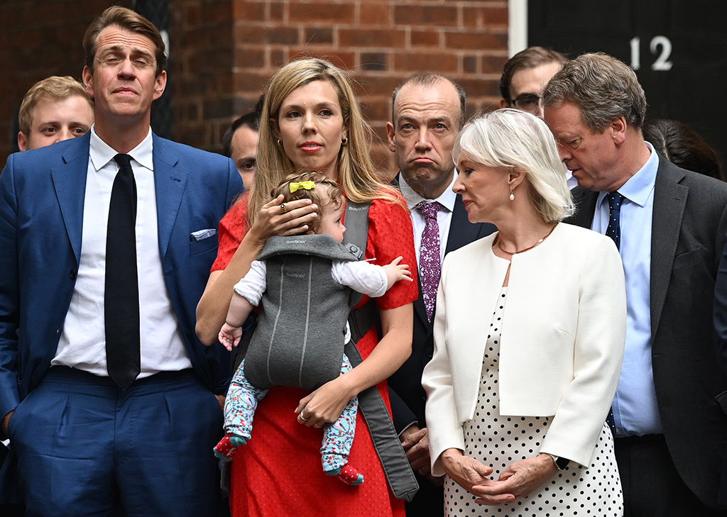 LONDON: Carrie Johnson, wife of Britain's Prime Minister Boris Johnson, carries their daughter Romy next to Britain's Culture Secretary Nadine Dorries (R) ahead of a statement by the premier in front of 10 Downing Street in central London on July 7, 2022. - AFP
