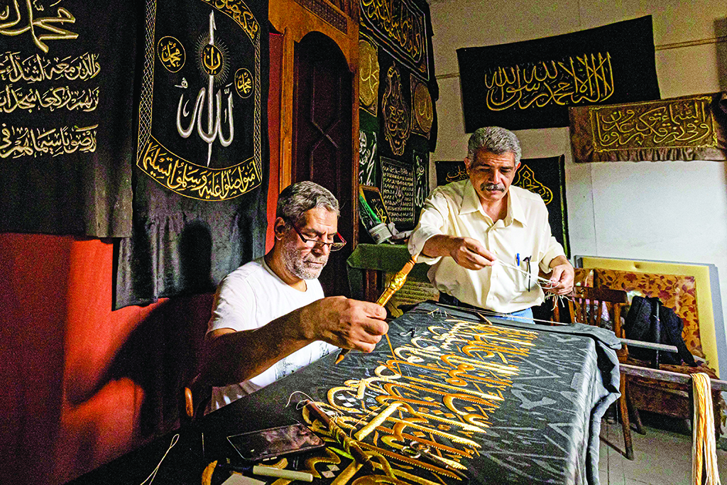 Egyptian embroiderer Ahmed Othman El-Kassabgy (right), whose family was traditionally responsible for the task of producing the Kiswa, the cloth used to cover the Kaaba at the Grand Mosque in the Muslim holy city of Makkah, supervises as another employee. - AFP photos