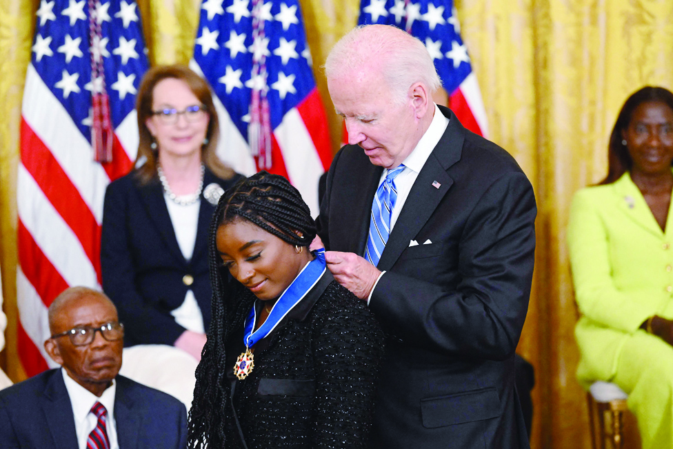 WASHINGTON: US President Joe Biden presents gymnast Simone Biles with the Presidential Medal of Freedom, the nation's highest civilian honor, during a ceremony honoring 17 recipients, in the East Room of the White House in Washington, DC.- AFP