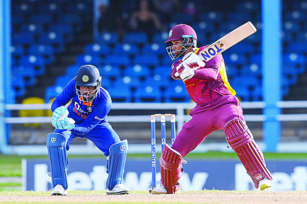 PORT OF SPAIN: Brandon King (right) of West Indies hits 4 and Sanju Samson of India watches during the 1st ODI match between West Indies and India at Queens Park Oval, Port of Spain, Trinidad and Tobago, on July 22, 2022. - AFP